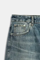 Jeans de tiro alto con diseño balloon, cinco bolsillos y costuras laterales torcidas. Presenta cierre frontal con cremallera y botón metálico.