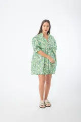 Vestido corto verde con estampado floral, cuello alto, mangas cortas abullonadas y corte holgado.