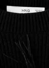 Sweater de punto grueso color negro, con cuello redondo, diseño recto y manga larga, adornado con aplicaciones de plumas de avestruz en el pecho y las mangas.