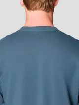 Buzo de cuello redondo color azul, con puños y bajo acanalados. Presenta un pequeño logo bordado en el pecho.