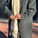 Bufanda de lana color azul marino con flecos en los extremos.