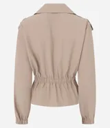 Campera corta tipo trench de viscosa color beige, con doble botonadura frontal, solapa ancha, detalle en los hombros con botones, mangas largas abullonadas con puños elásticos y cintura fruncida con elástico.
