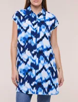 Túnica de gasa negra con estampado floral en tonos azules y blancos, cuello camisero, manga corta y cierre frontal de botones.