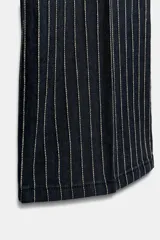 Jeans de tiro alto con corte flare y diseño de rayas verticales. Presenta cintura con trabillas, falsos bolsillos delanteros con solapa y botón, y cierre frontal con cremallera y botón.