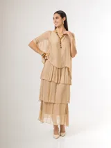 Vestido largo color beige de seda italiana, con falda de volados y sobrecapa superior. Confeccionado en tejido liviano y fluido con diseño elastizado.