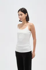 Musculosa de poliamida con breteles finos, corte al cuerpo y escote redondo.