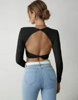 Top negro de lycra morley, manga larga, con espalda descubierta y nudo en la parte inferior.