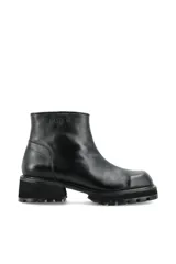 Bota de caña corta marca Pastiche, confeccionada en cuero negro con punta cuadrada y suela de goma tipo track con taco cuadrado.