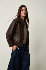 Campera corta de cuero sintético marrón, con cuello camisero y cierre frontal.