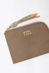 Monedero compacto de Bimba y Lola en color bordó, con cierre de cremallera superior y logo metálico dorado en el frente.