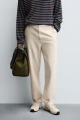 Pantalón chino de corte recto confeccionado en tejido ligero de algodón con estructura canvas. Presenta bolsillos frontales, bolsillos traseros de vivo y cierre frontal con cremallera y botón.