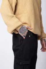 Pantalón cargo negro con múltiples bolsillos laterales y ajuste en los tobillos.