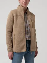 Campera polar de tejido melange en tono caramelo, con cuello alto, cierre frontal completo y bolsillos laterales e incorporado en el pecho con tiradores.