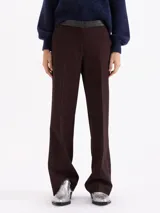 Pantalon de corte recto confeccionado en tela sastrera color marrón oscuro, con cintura de cuero vacuno al tono, raya marcada en el centro de las piernas y bolsillos laterales.