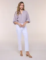Pantalón ankle de tiro alto color blanco, confeccionado en tejido elástico con pretina ancha tipo pull-on, corte entallado y detalle de encaje calado en las aberturas laterales del ruedo.