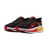 Championes de running Nike Vomero 18, color negro con detalles en naranja y amarillo. Presentan tecnología ZoomX en la entresuela para mayor amortiguación y diseño aerodinámico con el logo de la marca en el lateral.