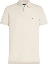 Chomba color beige de Tommy Hilfiger, modelo 1985, de corte regular y mangas cortas. Presenta cuello tipo chomba, cartera de dos botones, diseño de rayas en el interior del cuello y logo bordado en el pecho.