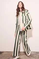 Sobrecamisa oversize con estampado a rayas verticales verdes y blancas, con cuello clásico, cierre frontal con botones y bolsillos de parche en el pecho.