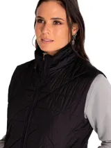 Chaleco acolchado negro de poliéster, con diseño capitoné en rombos, cuello alto y cierre frontal completo con cremallera. Cuenta con bolsillos laterales con cierre.