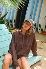 Buzo con capucha de tejido de punto abierto (calado) color marrón oscuro, con diseño oversize y flecos en los puños de las mangas.