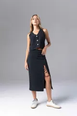 Falda midi negra con finas rayas verticales blancas, corte recto y abertura lateral con cordones cruzados.