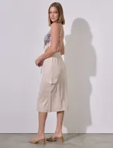 Falda midi color beige de modal, con pretina elastizada con cordón ajustable, corte recto y bolsillos cargo laterales.