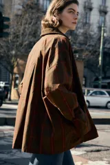 Chaqueta de mujer de la colección Zara Woman, confeccionada en algodón 100% con acabado encerado. Presenta un estampado a cuadros en tonos marrón y rojo, cuello solapa de pana, manga larga con puño y botón, bolsillos de plastrón con solapa en el delantero y cierre frontal con botones a presión.