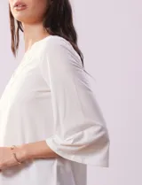 Blusa color blanco con escote en V y aplique de crochet.