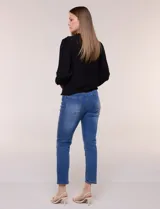 Blusa negra de rayón con textura smock en la pechera, escote en V con cuello mao fruncido, mangas largas fluidas con puños anchos y detalle de volados en el ruedo.