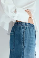 Pantalón de jean de corte holgado y pernera recta, color celeste con efecto deslavado. Cuenta con cintura elástica fruncida y cordón ajustable.