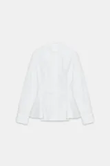 Camisa de popelín de algodón con cuello solapa, manga larga con puños y bajo con diseño peplum. Presenta cierre frontal oculto con botones.