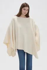 Poncho crudo de tejido de punto con diseño holgado y sin mangas.