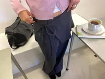 Pantalón sastrero gris a rayas verticales, de tiro alto con bolsillos y pretina trasera elastizada.