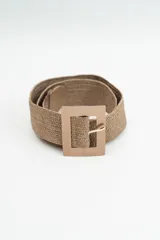 Cinturón de tejido trenzado color marrón, con hebilla rectangular metálica en tono dorado mate.