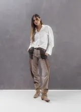 Pantalon de gabardina corte barrel con diseño de paneles en tonos tierra. Presenta un calce tipo babucha con estructura bombé, costuras reforzadas con pespuntes en contraste y cierre frontal con botón.