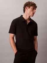 Chomba de manga corta Calvin Klein confeccionada en algodón interlock, con cuello clásico y cierre frontal de dos botones.