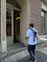 Remera blanca de algodón con corte oversize y estampado en la espalda con diseño geométrico en negro y la palabra 'OSTER' en la parte inferior.