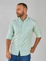 Camisa celeste a rayas verticales blancas, de manga larga con cuello abotonado y bolsillo en el pecho.