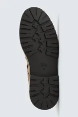 Zapato tipo Mary Jane de hombre, color marrón, fabricado en piel con acabado serraje (gamuza). Presenta cierre con hebilla lateral, detalle de bordón en el empeine y suela gruesa con volumen.