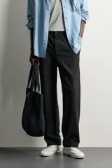 Pantalón negro confeccionado en mezcla de algodón, con cintura elástica, bolsillos frontales y cierre con cremallera y botón.