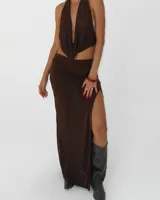 Falda larga de color marrón chocolate, con tiro medio y un tajo lateral pronunciado que deja la pierna al descubierto.