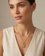 Collar de acero con baño de oro, con cadena de eslabones finos y dije rectangular de superficie texturizada con incrustaciones de circonias multicolor.