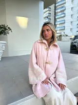 Saco capa color rosa de tejido de lana con cierre de broches tipo duffle coat y detalle de tejido calado en las mangas.