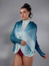 Saco largo de lana merino tejido con diseño jacquard de ramas, de líneas rectas y aberturas laterales, con efecto degradado en tonos azules y blancos, mangas largas con puños entallados y cierre frontal con pequeños botones.