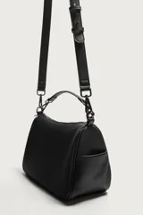 Bandolera negra de acabado liso, con compartimento principal con cierre de cremallera, bolsillos laterales planos y un bolsillo interior con cremallera. Incluye asa de mano extraíble y asa de hombro ajustable y extraíble.