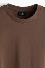 Remera de manga larga en punto pesado, con cuello redondo, hombros caídos y bajo recto. Presenta un corte oversized para una silueta holgada.