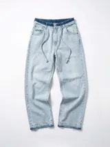 Pantalón de jean celeste lavado, de corte ancho y tiro alto con cordón ajustable en la cintura. Presenta detalles deshilachados en los bajos.