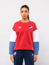 Buzo de cuello redondo con diseño de bloques de color en rojo, blanco y azul. Presenta el logo de Umbro y el escudo del Club Nacional de Football bordados en el pecho.
