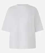 Blusa básica de mujer color negro, confeccionada en malla encorpada de algodón, con cuello redondo y mangas cortas de corte oversized con sisas desplazadas.