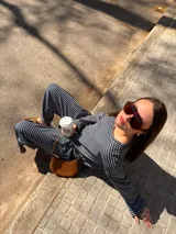Conjunto de dos piezas de viscosa color beige con diseño de rayas horizontales blancas, compuesto por una remera de manga larga holgada y un pantalón de corte ancho.